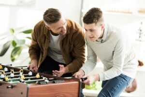 indoor game tables - a father and son playing foosball